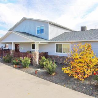 A residential house with a driveway and autumn foliage.