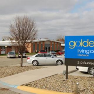 Image of a nursing home with a parking lot and a sign reading 'golden living center'.