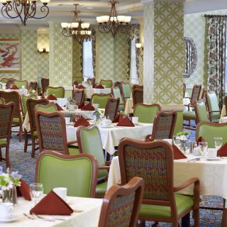 An elegant dining area with neatly arranged tables and chairs, featuring a classic interior design.