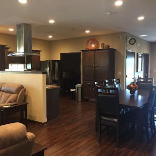 Modern open concept kitchen and dining area with wood flooring and recessed lighting.
