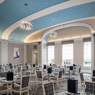 A modern conference room with chandeliers, arched ceilings, and large windows.