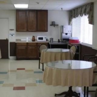 A small kitchen area with tables and chairs for dining.