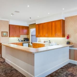 A modern kitchen with wooden cabinets and a spacious countertop.
