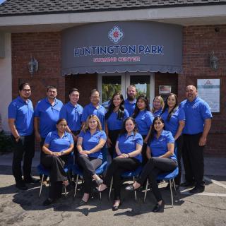 A team of people in blue uniforms posing for a group photo outside a building.