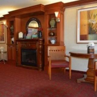 A traditional room with wooden paneling, featuring a fireplace and elegant furnishings.