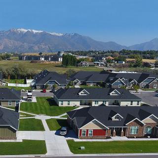 A suburban neighborhood with houses and a scenic mountain backdrop under a clear blue sky.