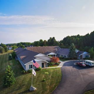 Aerial view of a nursing home with surrounding greenery and driveway entrance.