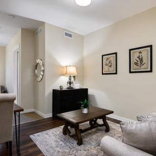 A cozy living room with a sofa, coffee table, and decorative artwork on the walls.