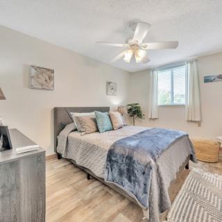 A modern bedroom with a comfortable bed, ceiling fan, and stylish decor.
