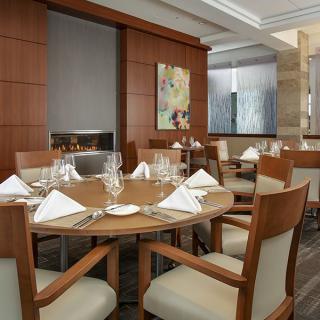 An elegant restaurant interior with a neatly set dining table.