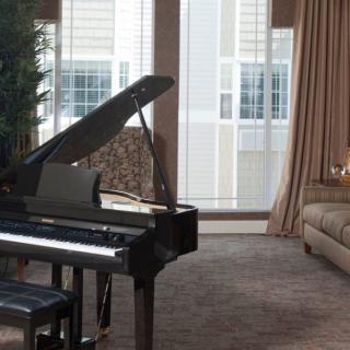 A cozy living room featuring a grand piano and comfortable seating.