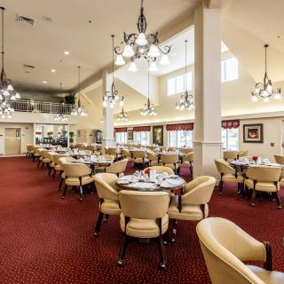 Spacious and elegantly designed dining area with chandeliers and neatly arranged tables.