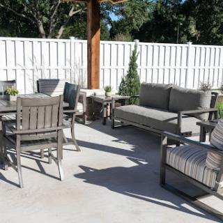 A stylish outdoor patio setup featuring comfortable seating and a dining table.