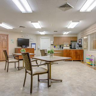 Cozy dining and communal area with modern furniture and a kitchenette.