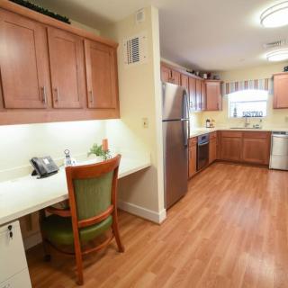 A spacious kitchen with wooden cabinets, a desk area, and stainless steel appliances.