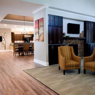 A modern open-layout space featuring a living room with a fireplace and an adjacent dining area.