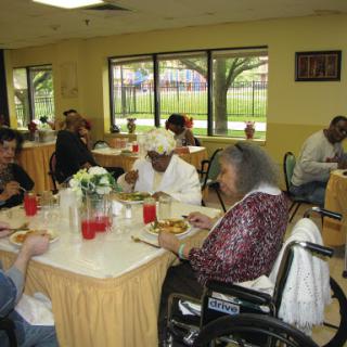 Seniors enjoying a meal together in a communal dining area.
