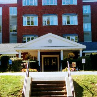 A welcoming entrance to a brick building with steps leading up to the doorway.