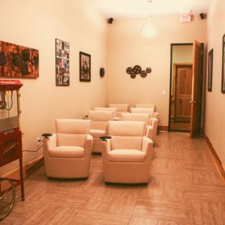 A cozy home theater room with comfortable seating and a popcorn machine.