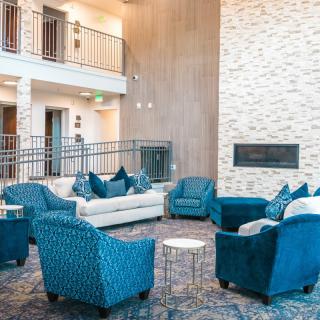 A stylish and modern lounge area featuring blue upholstered seating and a fireplace.