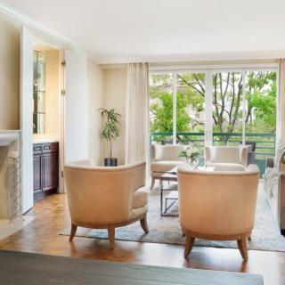 A bright and modern living room with elegant furniture and large windows allowing natural light.