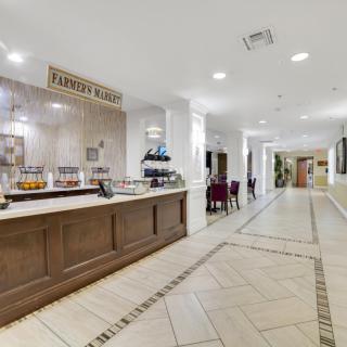 A hotel breakfast area featuring a buffet counter and dining tables.
