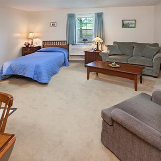 A cozy bedroom with a bed, sofa, and coffee table, decorated in a simple style.