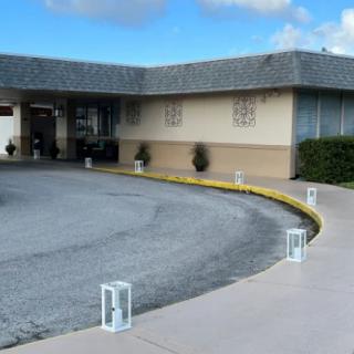 A building with a curved driveway and entrance on a cloudy day.