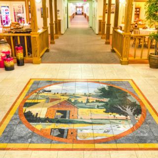 A beautifully detailed floor mural stands as the focal point in a brightly lit hallway.