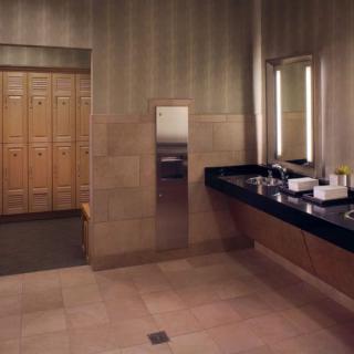 A modern locker room with wooden lockers, sinks, and mirrors.