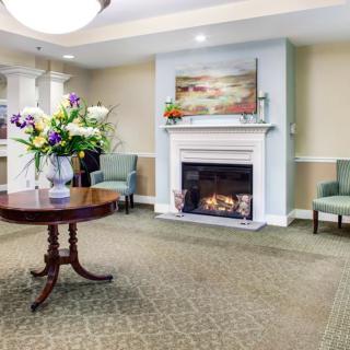 A cozy living room with a fireplace and decorative flowers.