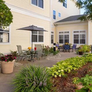 A cozy patio area with outdoor seating and a lush garden.