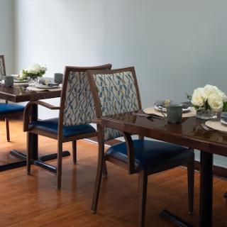 A stylish dining area featuring elegant tables and chairs, complemented by floral arrangements.