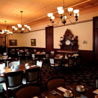 A classic dining room interior with elegant chandeliers and neatly arranged tables.