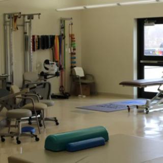 A well-equipped physical therapy and rehabilitation room with various exercise equipment.