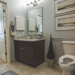 A modern bathroom with a sink, mirror, and toilet.