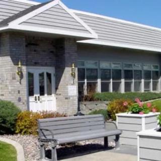 A small building with a bench and landscaped surroundings.