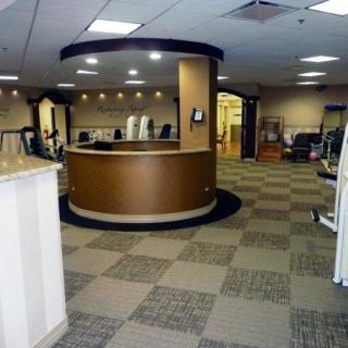 A modern office reception area with a round desk and checkered flooring.