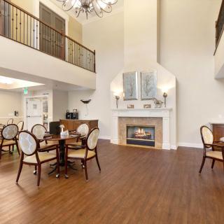 A spacious living area featuring a fireplace and dining setup with elegant furniture and high ceilings.