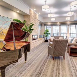 A modern lobby with a grand piano and a comfortable seating area.