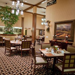 A well-decorated restaurant dining area with neatly arranged tables and elegant lighting.
