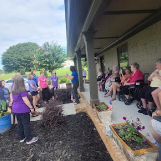 A group of volunteers gathers for a community gardening event, engaging in teamwork and outdoor activities.