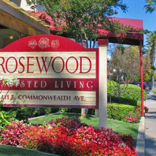 Sign for Rosewood Assisted Living surrounded by vibrant landscaping.
