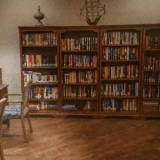 A cozy library room with wooden bookshelves filled with books.
