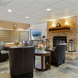 A cozy lobby interior featuring a fireplace, comfortable seating, and elegant decor.