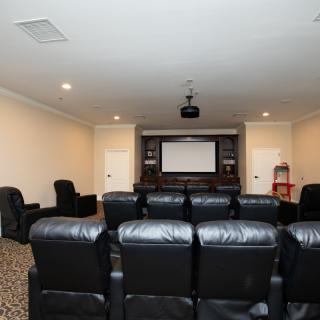 A home theater setup with comfortable leather seating and a large projector screen.