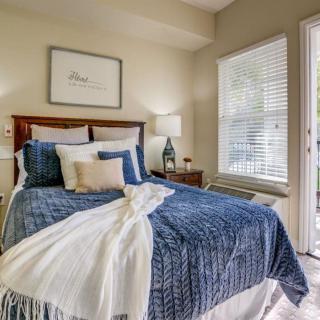 A cozy bedroom with blue bedding and ample natural light.