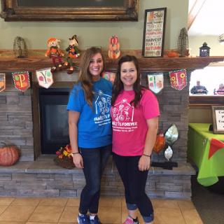 Two friends posing together in colorful shirts at a festive gathering.