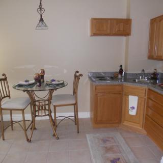 A cozy kitchen and dining area with wooden cabinets and a small round table set.