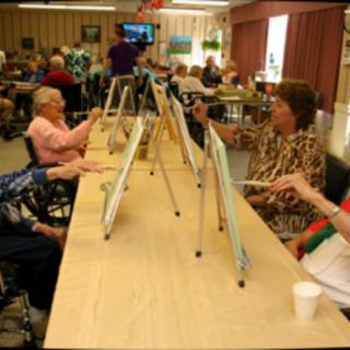 A group of elderly individuals participating in a painting class.